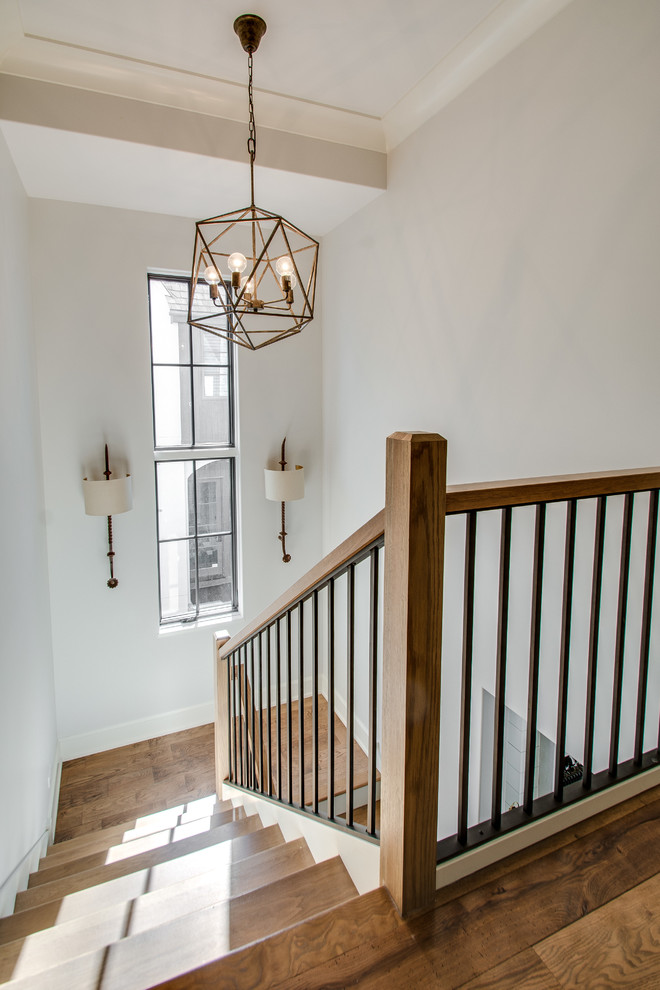 На фото: п-образная лестница среднего размера в стиле кантри с деревянными ступенями и крашенными деревянными подступенками