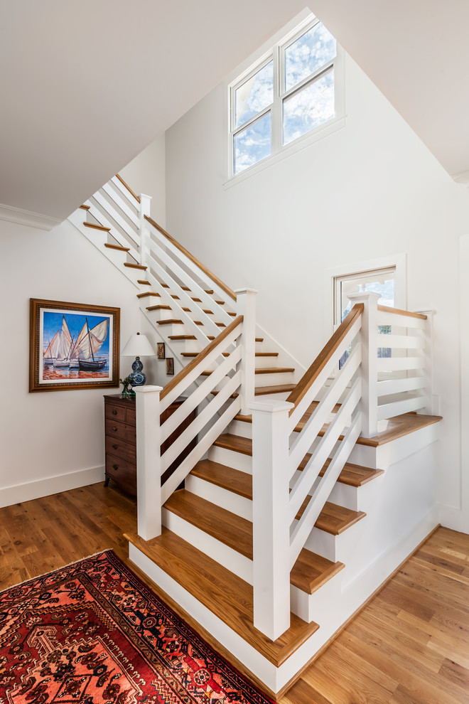 Идея дизайна: большая угловая лестница в стиле кантри с деревянными ступенями, крашенными деревянными подступенками и деревянными перилами