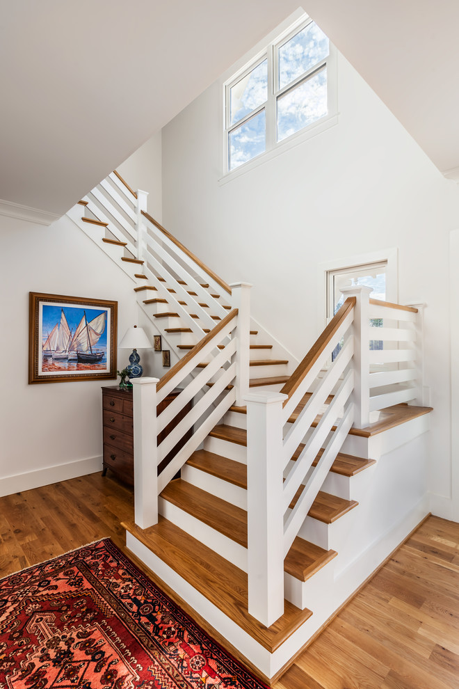 Réalisation d'un grand escalier peint champêtre en L avec des marches en bois, un garde-corps en bois et éclairage.