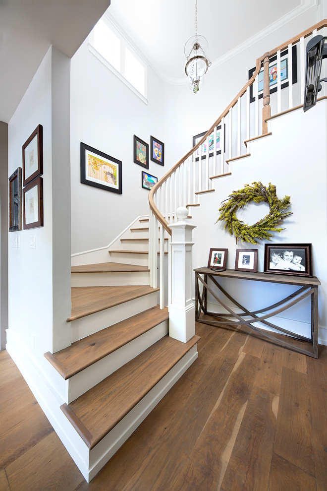 Cette image montre un escalier peint courbe rustique de taille moyenne avec des marches en bois et un garde-corps en bois.