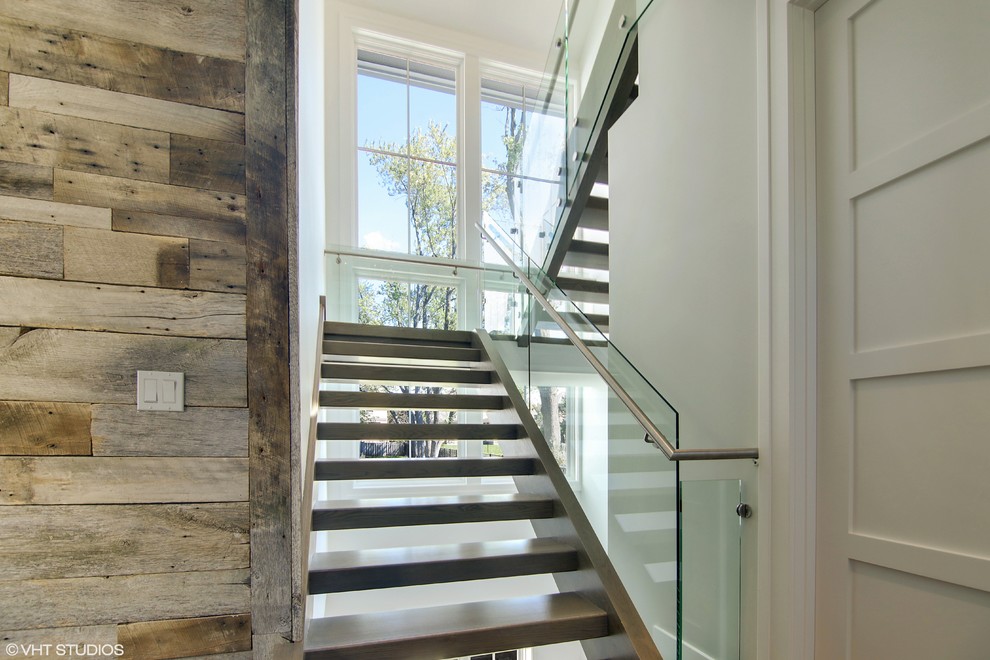 Cette image montre un escalier flottant minimaliste avec des marches en bois et des contremarches en bois.
