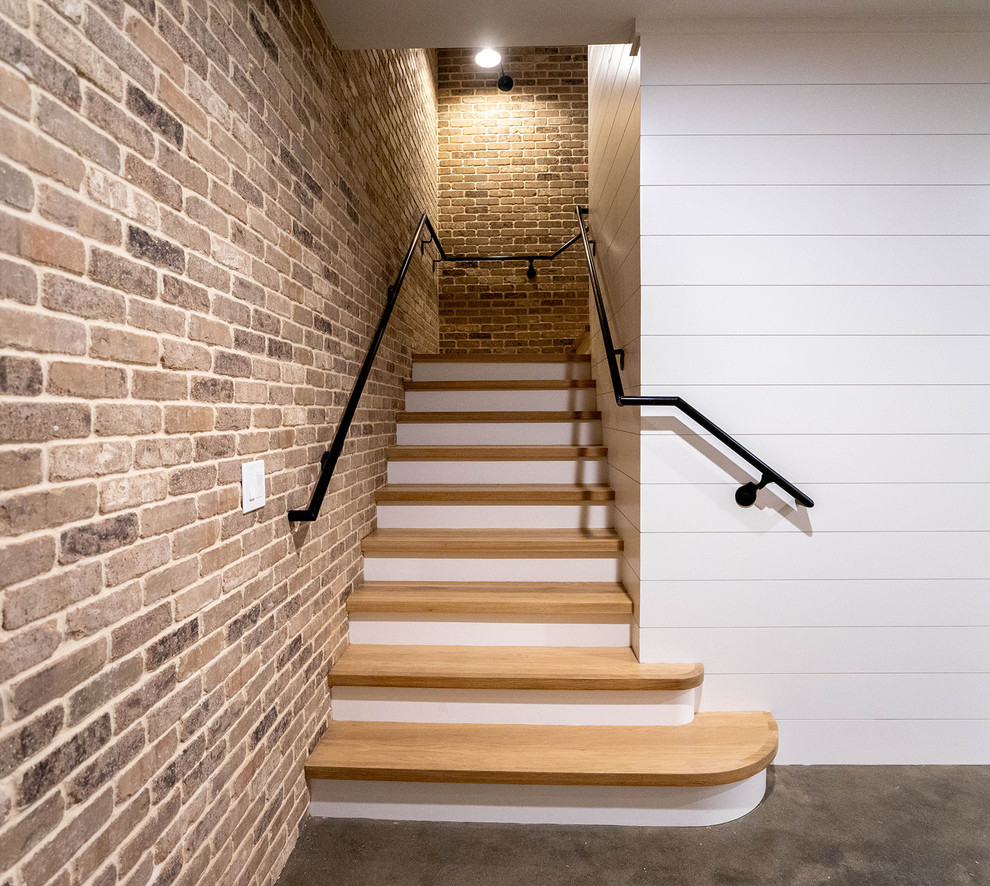 Imagen de escalera en L de estilo de casa de campo grande con escalones de madera, contrahuellas de madera y barandilla de metal