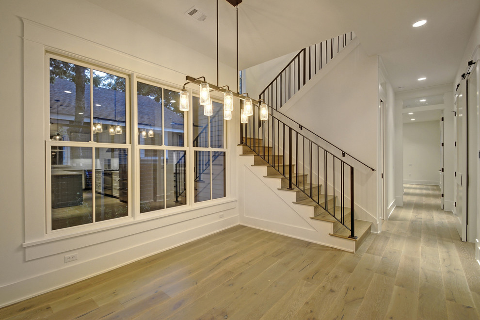 Ejemplo de escalera en U de estilo de casa de campo de tamaño medio con escalones de madera, contrahuellas de madera y barandilla de metal