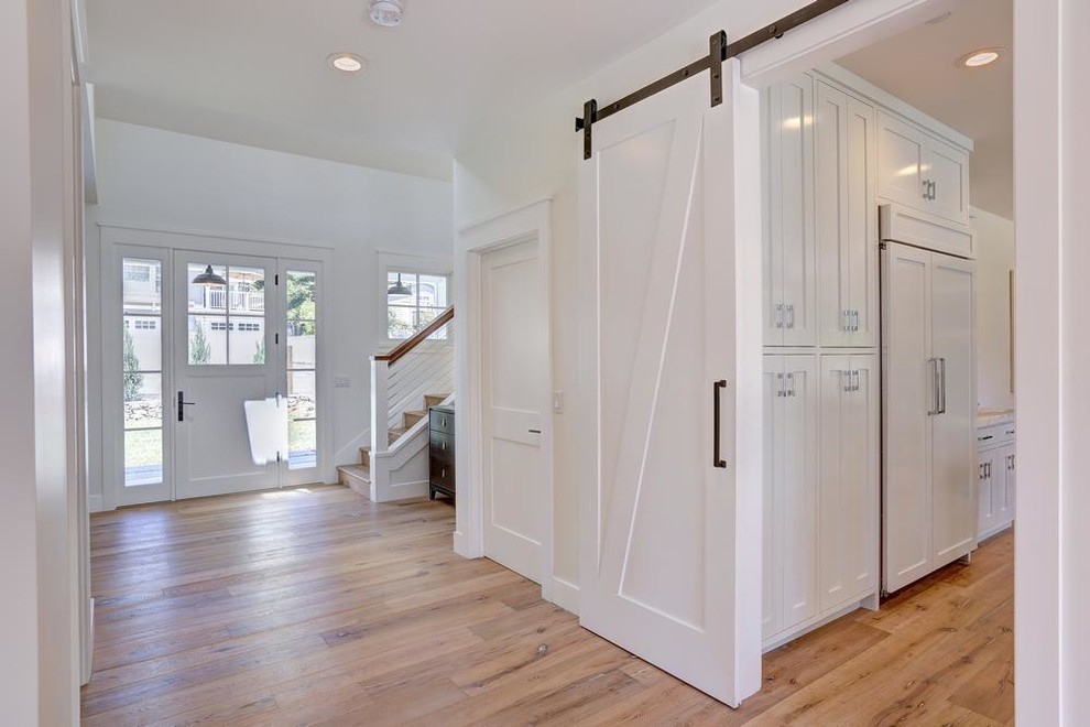 This is an example of a large farmhouse wood u-shaped wire cable railing staircase in San Francisco with wood risers.