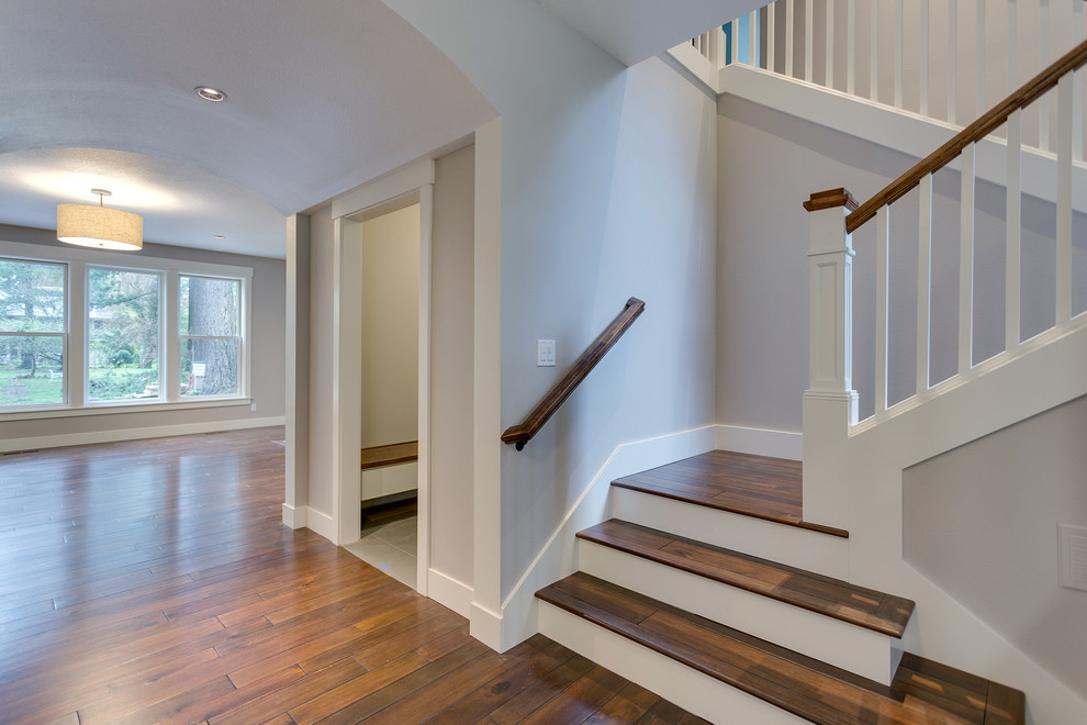 Photo of a medium sized country wood u-shaped wood railing staircase in Salt Lake City with painted wood risers.