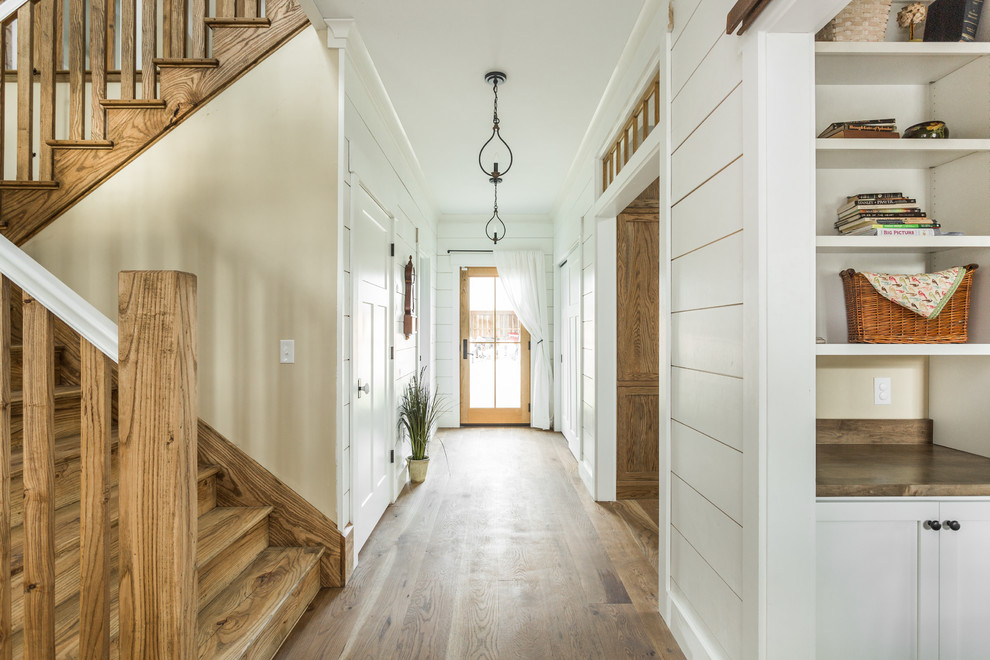 Imagen de escalera en U de estilo de casa de campo grande con escalones de madera y contrahuellas de madera