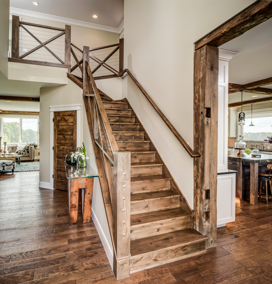 Idée de décoration pour un escalier champêtre en L avec des marches en bois, des contremarches en bois et un garde-corps en bois.
