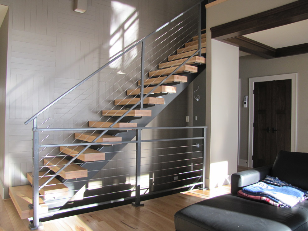 На фото: прямая лестница среднего размера в стиле модернизм с деревянными ступенями и перилами из тросов без подступенок с