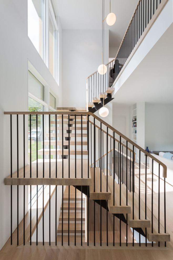 Пример оригинального дизайна: большая п-образная лестница в стиле модернизм с деревянными ступенями и металлическими перилами без подступенок