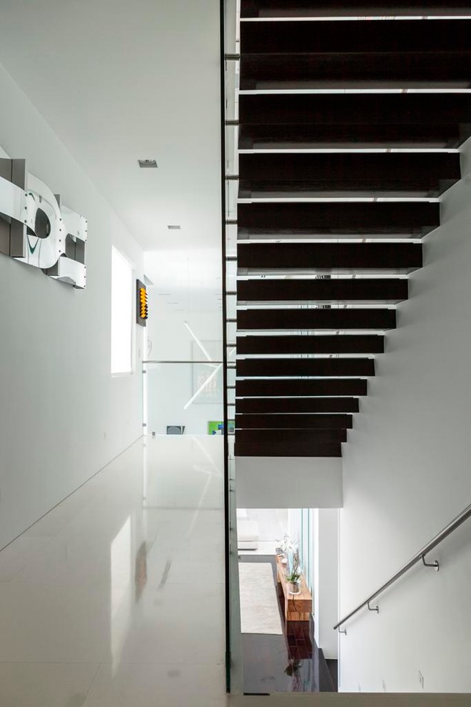 Diseño de escalera suspendida contemporánea de tamaño medio con escalones de madera y contrahuellas de madera