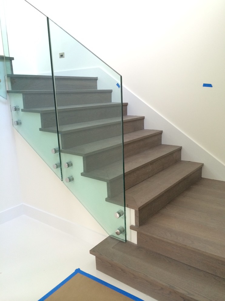 Ejemplo de escalera suspendida minimalista con escalones de madera y contrahuellas de madera