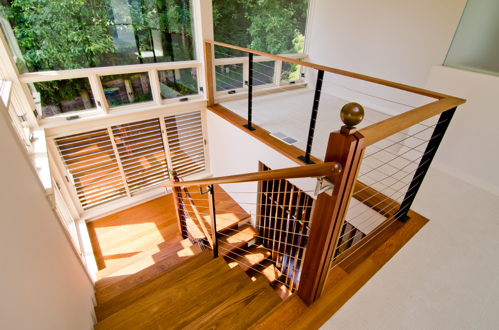 Свежая идея для дизайна: п-образная лестница среднего размера в стиле модернизм с деревянными ступенями и перилами из тросов без подступенок - отличное фото интерьера