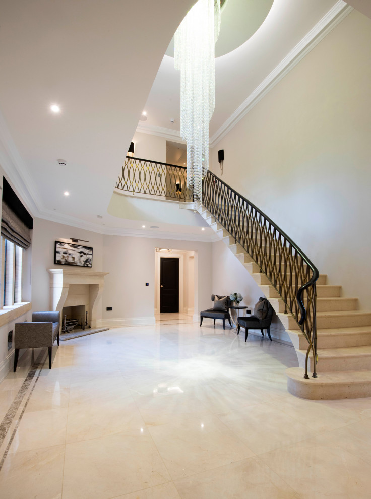 Стильный дизайн: большая изогнутая лестница в стиле модернизм с ступенями из травертина, подступенками из травертина и металлическими перилами - последний тренд