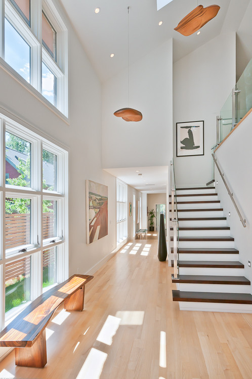 Идея дизайна: большая прямая лестница в стиле модернизм с деревянными ступенями и крашенными деревянными подступенками