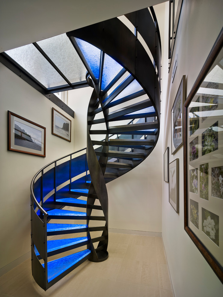 Imagen de escalera de caracol actual sin contrahuella con escalones de vidrio