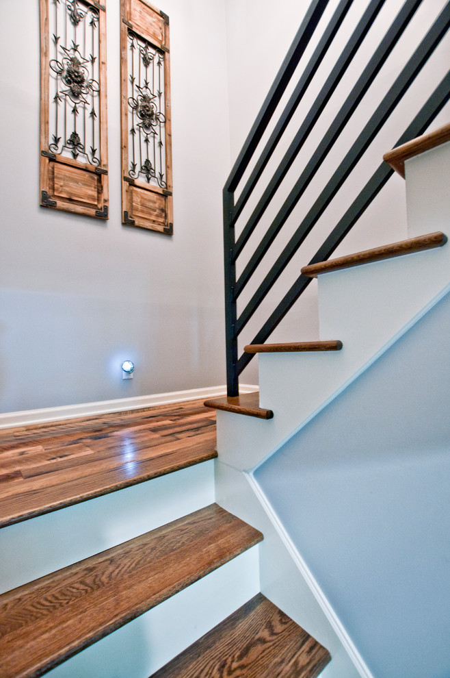 Foto de escalera en U clásica renovada de tamaño medio con escalones de madera, contrahuellas de madera y barandilla de metal