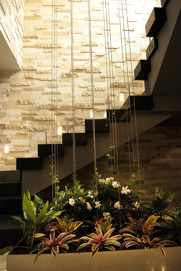 Idée de décoration pour un escalier peint flottant minimaliste de taille moyenne avec des marches en métal et un garde-corps en verre.