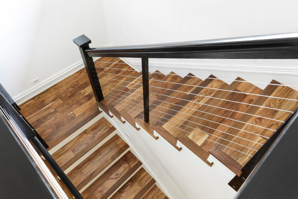 Imagen de escalera en U de estilo de casa de campo de tamaño medio con escalones de madera, contrahuellas de madera pintada y barandilla de cable