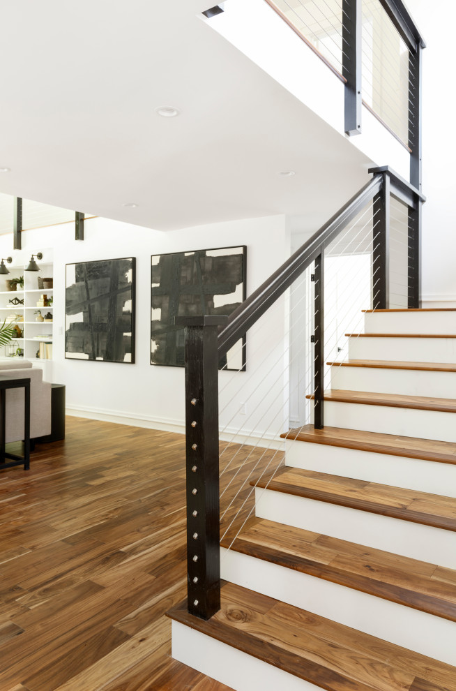 На фото: п-образная лестница среднего размера в стиле кантри с деревянными ступенями, крашенными деревянными подступенками и перилами из тросов с