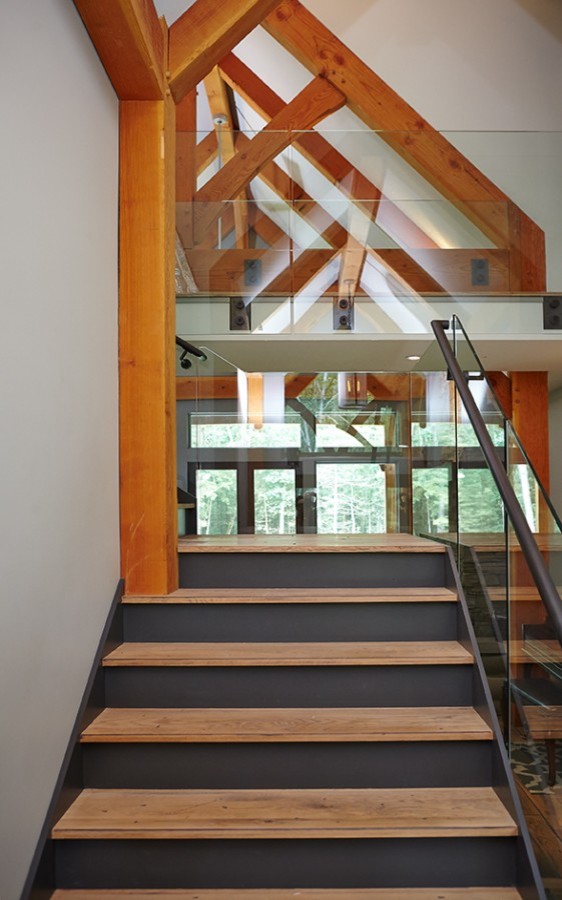 Foto di una scala minimalista con pedata in legno, alzata in legno verniciato e parapetto in metallo