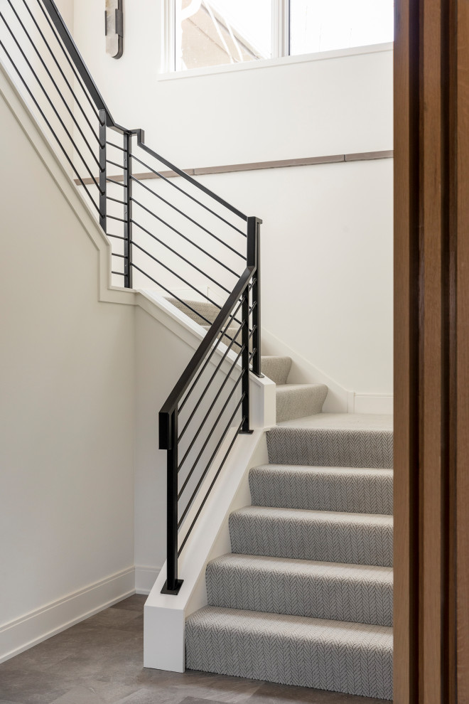 Стильный дизайн: лестница на больцах в стиле кантри с ступенями с ковровым покрытием и металлическими перилами - последний тренд