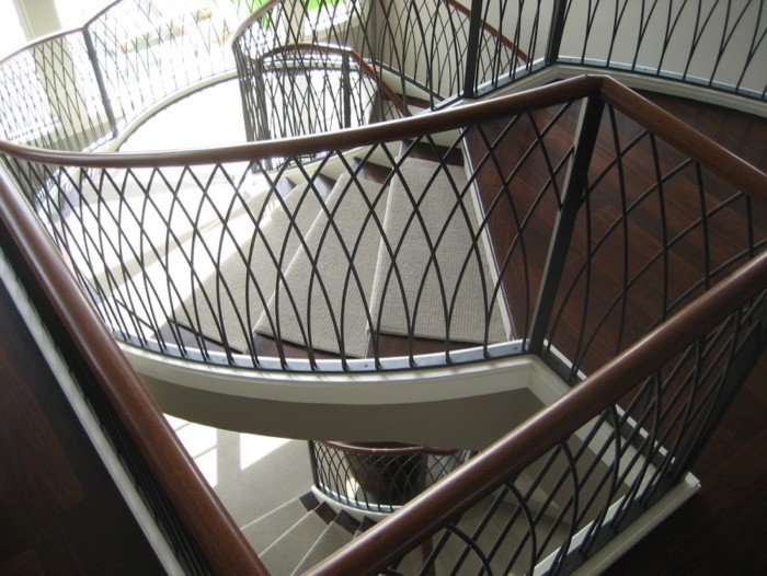 This is an example of an expansive modern carpeted spiral staircase in San Francisco with carpeted risers.