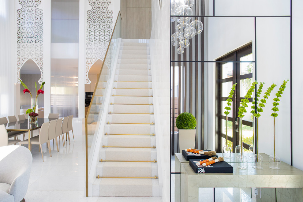 Стильный дизайн: большая прямая лестница в стиле модернизм с мраморными ступенями, подступенками из мрамора и металлическими перилами - последний тренд