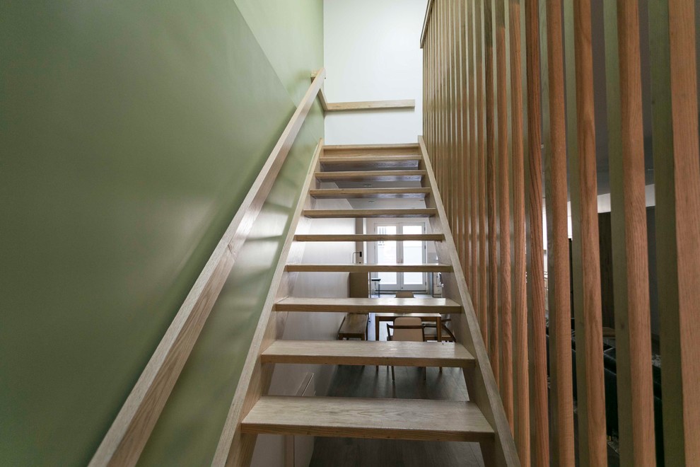 Exempel på en mellanstor modern rak trappa i trä, med öppna sättsteg och räcke i trä