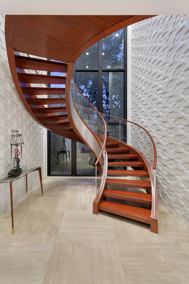 На фото: изогнутая лестница в современном стиле с деревянными ступенями и стеклянными перилами
