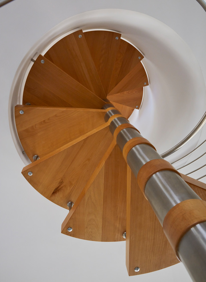 Modelo de escalera de caracol minimalista grande sin contrahuella con escalones de madera y barandilla de metal