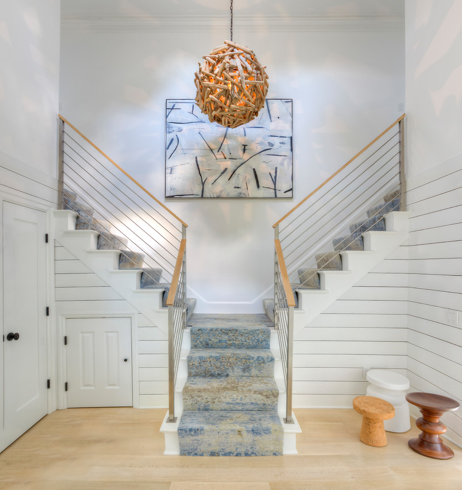 Medium sized nautical carpeted u-shaped wire cable railing staircase in New York with carpeted risers.