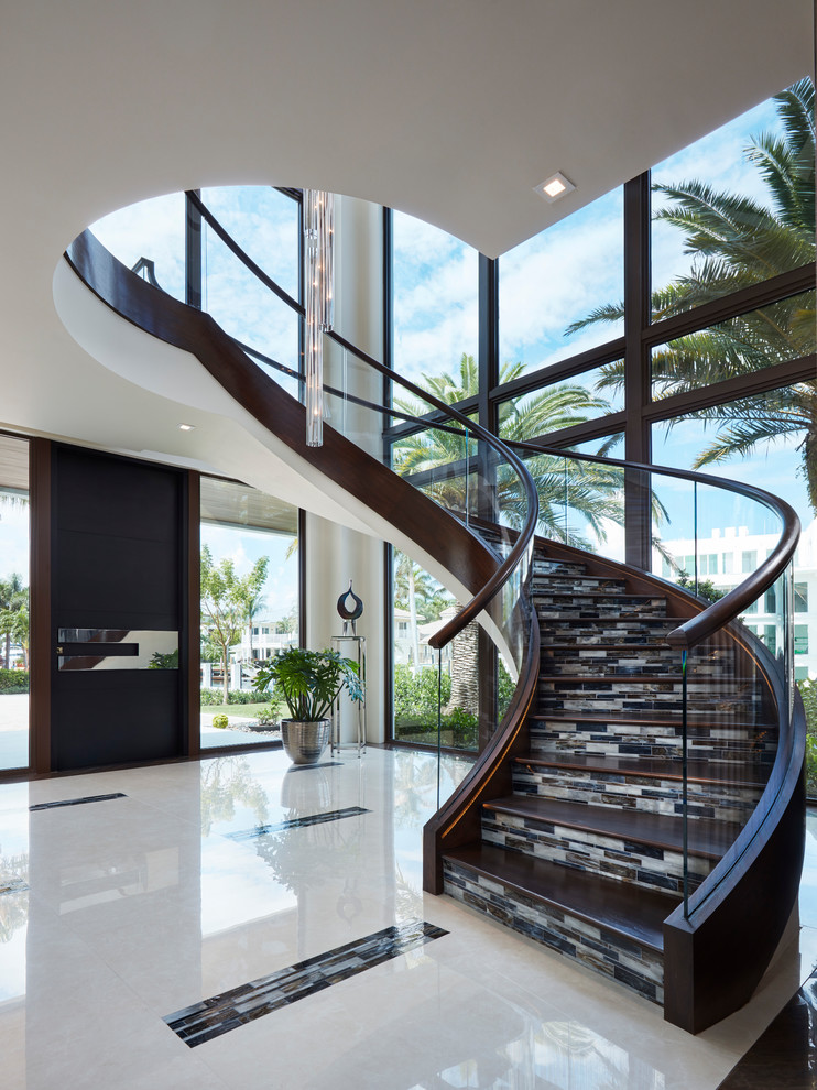 Idée de décoration pour un escalier courbe design avec des marches en bois et un garde-corps en bois.