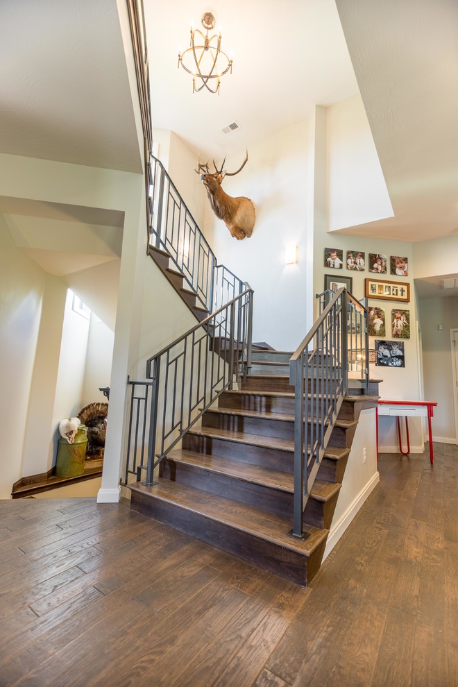 This is an example of a medium sized contemporary wood u-shaped metal railing staircase in Other with wood risers.