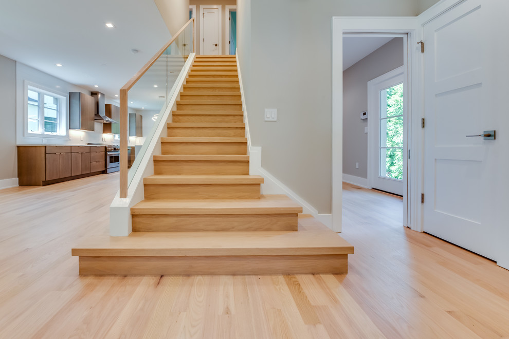 Diseño de escalera recta clásica renovada de tamaño medio con escalones de madera, contrahuellas de madera y barandilla de vidrio
