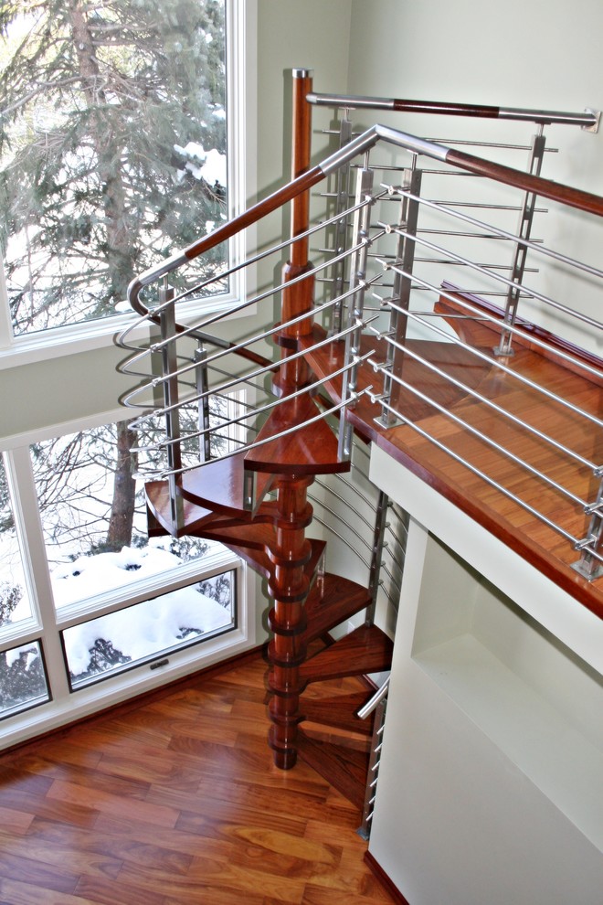 На фото: винтовая лестница среднего размера в стиле модернизм с деревянными ступенями и перилами из тросов без подступенок