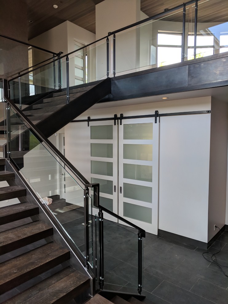 Источник вдохновения для домашнего уюта: большая угловая лестница в стиле модернизм с деревянными ступенями и стеклянными перилами без подступенок