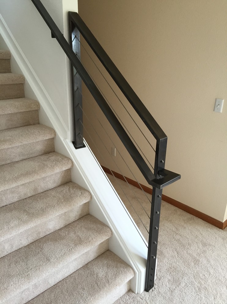Ejemplo de escalera recta minimalista de tamaño medio con escalones enmoquetados, contrahuellas enmoquetadas y barandilla de metal