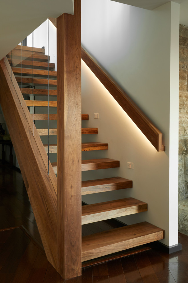 Пример оригинального дизайна: лестница на больцах в современном стиле с деревянными ступенями и перилами из смешанных материалов без подступенок