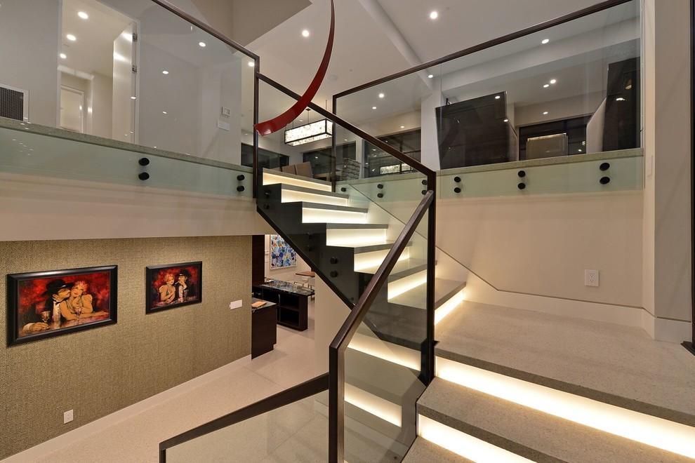 Foto de escalera en L contemporánea grande con contrahuellas de vidrio y barandilla de metal