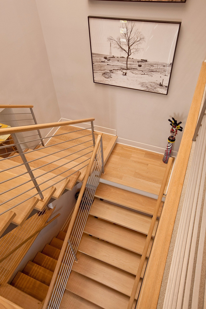 На фото: большая п-образная лестница в стиле модернизм с деревянными ступенями и металлическими перилами без подступенок