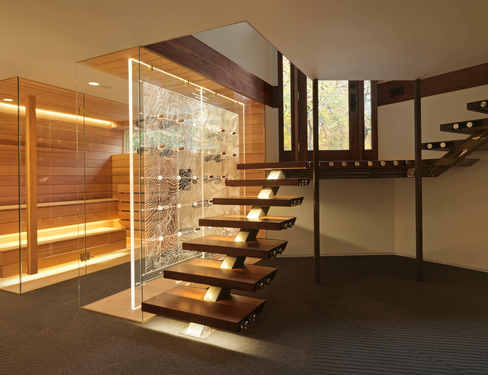 This is an example of a contemporary wood floating glass railing staircase in Burlington with open risers.