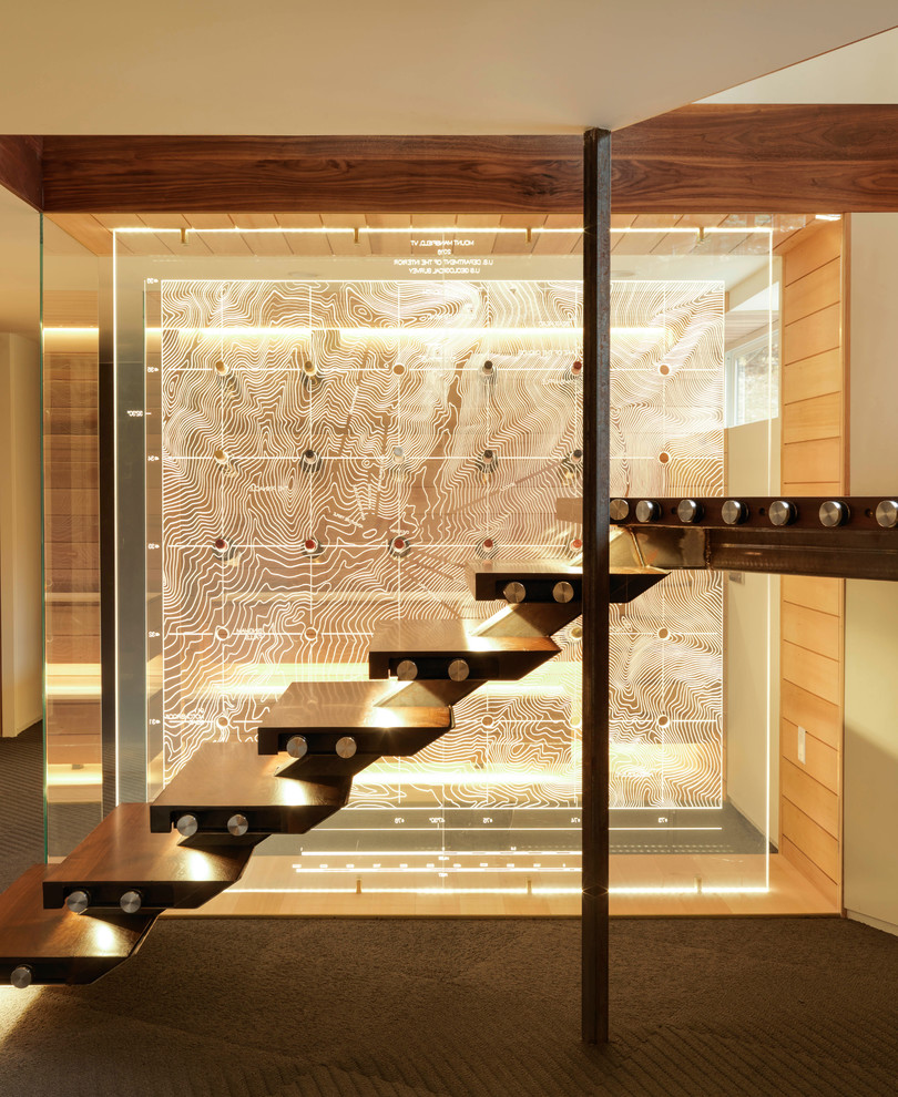 Example of a trendy wooden floating glass railing staircase design in Burlington with glass risers