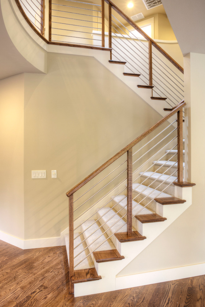 Diseño de escalera curva minimalista de tamaño medio con escalones de madera y contrahuellas de madera pintada