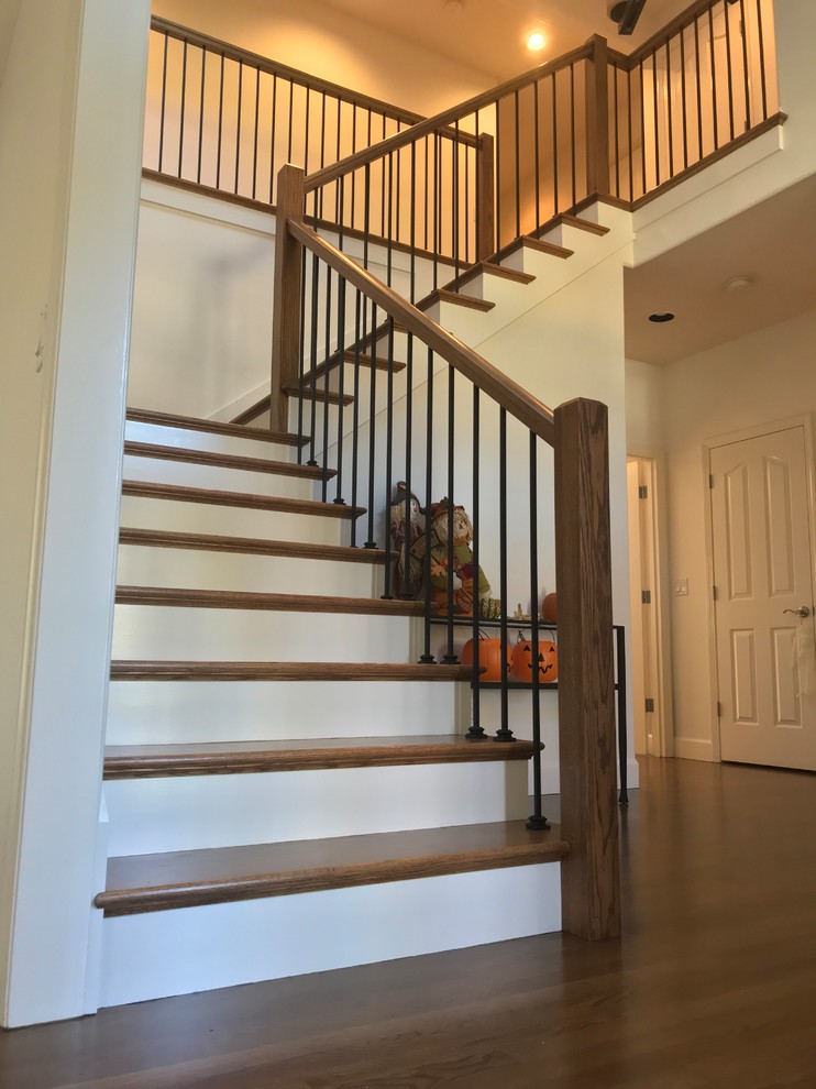 This is an example of a large midcentury wood l-shaped wood railing staircase in Portland with painted wood risers.