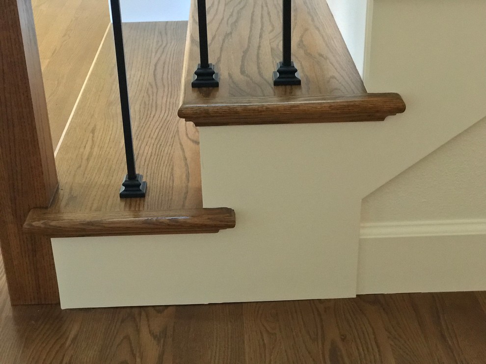 Large retro wood l-shaped wood railing staircase in Portland with painted wood risers.