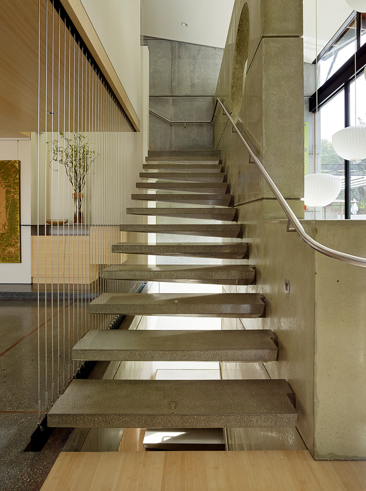 Стильный дизайн: лестница на больцах в стиле модернизм с бетонными ступенями и металлическими перилами без подступенок - последний тренд