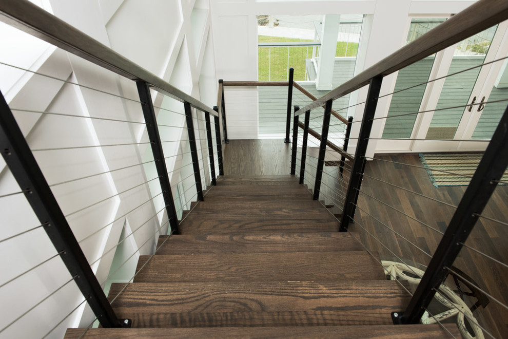 Design ideas for a large nautical wood floating wood railing staircase in Houston with metal risers.