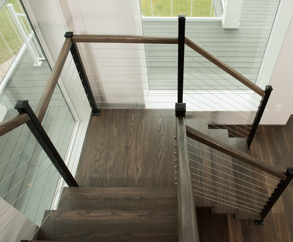 Ejemplo de escalera suspendida costera grande con escalones de madera, contrahuellas de metal y barandilla de madera