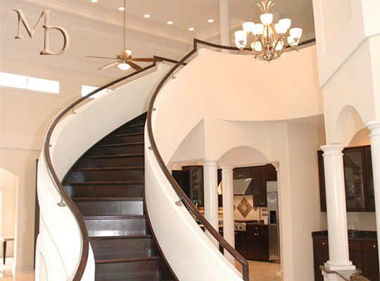 Cette image montre un grand escalier courbe traditionnel avec des marches en bois peint et des contremarches en bois.