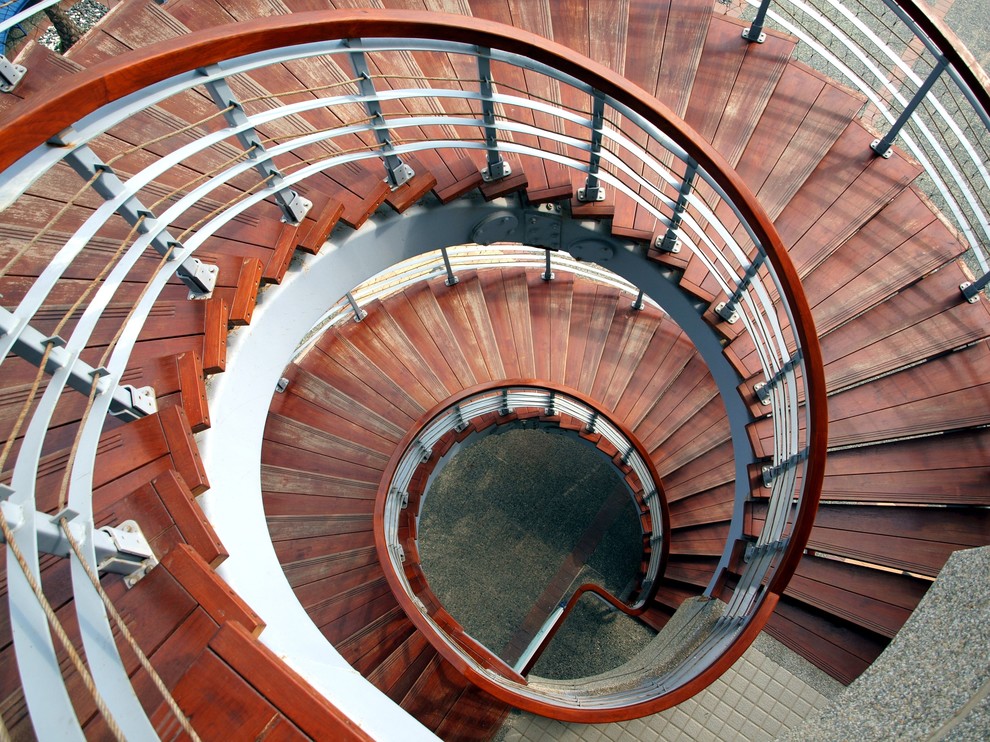 ニューヨークにあるラグジュアリーな巨大なラスティックスタイルのおしゃれならせん階段 (木の蹴込み板) の写真